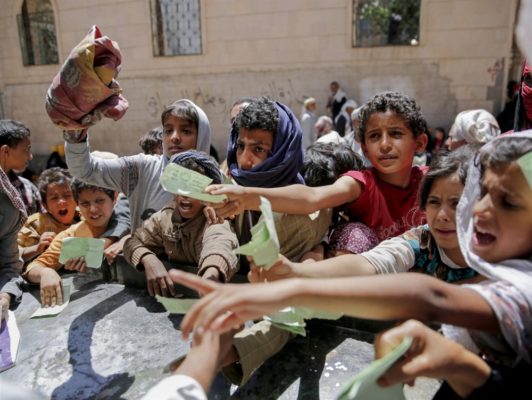 Yemeni children present documents to receive food rations