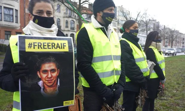 Amnesty International protestors hold #FreeRaif poster