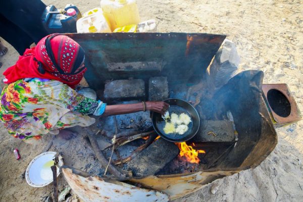 A woman cooks a meal at a camp for displaced people in al-Ghaidha, Yemen April 11, 2022. Picture taken April 11, 2022. REUTERS/Nusaibah Almuaalemi